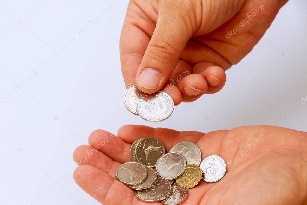 A man holds Croatian lipa coins in his hands on a white background. Croatian currency.