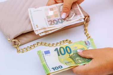 A female tourist holds kunas and euros on the background of a bag. Money exchange in tourist Croatia.