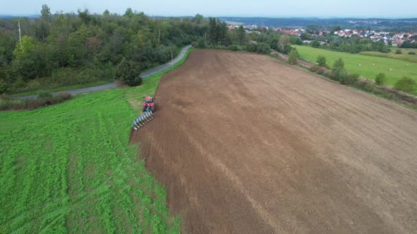 Red Tractor Plows Land Field Sown Green Manure Asphalt Road — Vídeo de stock