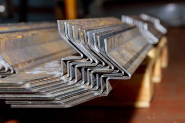 Bükme makinesinde işlem yaptıktan sonra bir yığın metal ürün. Metalürji endüstrisi.