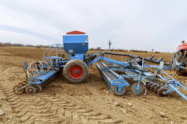 農家の畑で働くトラクターには種まき装置が取り付けられています この分野の近代的な技術 — ストック写真