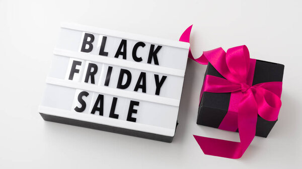 Black friday sale on light box with black gift box and pink bow on white background