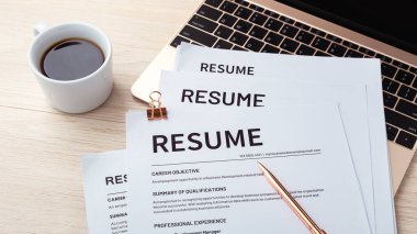 Bilgisayarda kalem ve kahve bardağıyla tahta masada devam et, tekrar gözden geçir, iş görüşmesi yap.