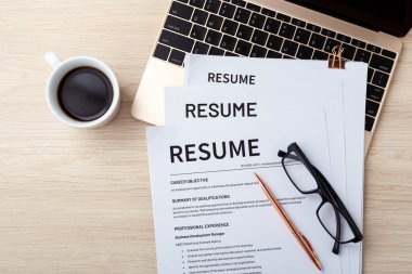 Dizüstü bilgisayarda, gözlüklü, kalem ve kahve bardağıyla tahta masanın üstünde, fotokopi alanı olan en üstte devam et.