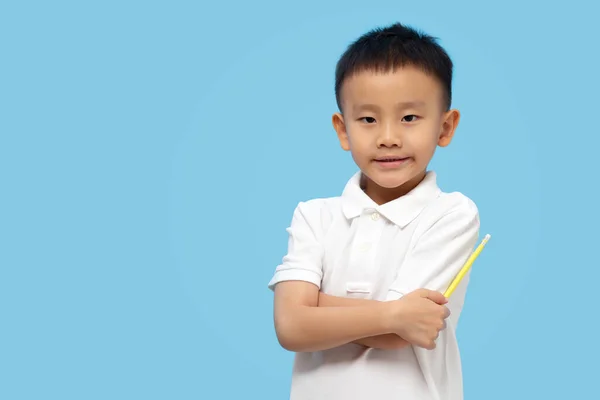 Inteligentny Dzieciak Krzyżujący Ramiona Trzymający Ołówek Niebieskim Tle — Zdjęcie stockowe