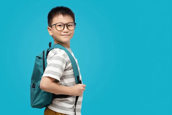 学校のバックパックを身に着けているスマート子供は ターコイズブルーの背景にTシャツを着て コピースペースで学校に戻る準備ができて — ストック写真