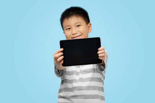 Felice Bambino Possesso Mostrando Tablet Weaing Tshirt Sfondo Blu — Foto Stock