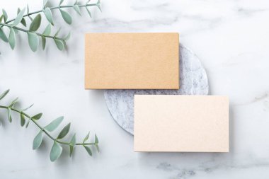 Kartvizit modeli, mermer üzerine yeşil yapraklı kraft kağıdı, düz konum