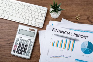 Hesap makinesi, bilgisayar ve finansal grafikle ilgili iş finans kavramı ahşap tablo üzerinde, üst görünüm
