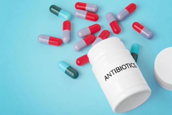 Laç Şişesinden Dökülen Kapsül Hapları Mavi Arka Planda Antibiyotik Konsepti — Stok fotoğraf