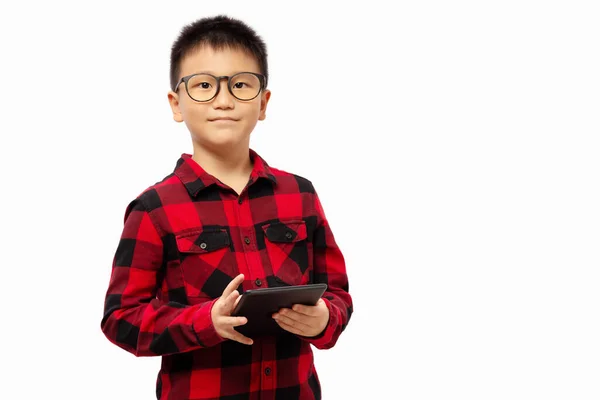 戴眼镜的孩子拿着平板电脑笑着看着被白色背景隔离的相机 — 图库照片