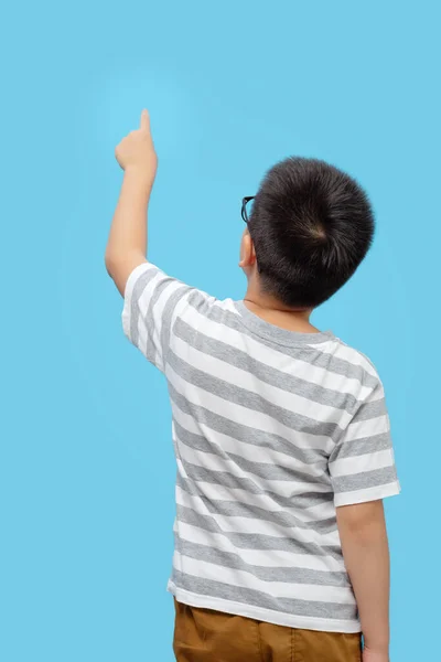 青の背景に 後ろのビューを押すと指す 眼鏡と指を持つ子供 — ストック写真