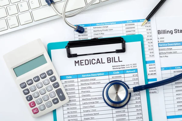 Medical bill with calculator and stethoscope on white desk, medical and health care cost concept