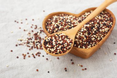 Kaşıkta karıştırılmış kinoa kalp ahşap kasede yer ile