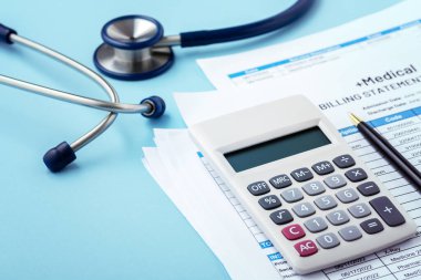 Medical bill concept with calculator and stethoscope on blue background