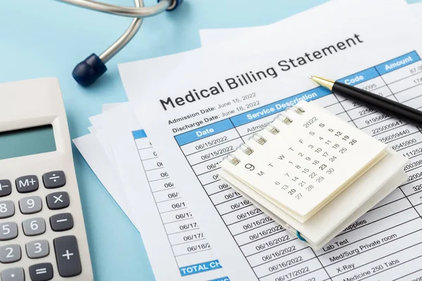 Calendar on medical billing statement with pen on blue background