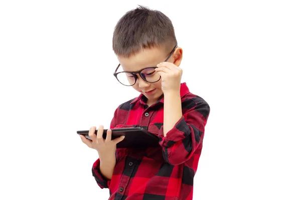 戴眼镜的孩子想从白色背景孤立的平板电脑上读一本书 — 图库照片