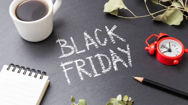 Black friday sale concept with coffee cup and stationery on black stone table