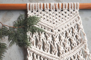 Beton zemin üzerinde köknar dalı olan el yapımı duvar dekorasyonu makromu