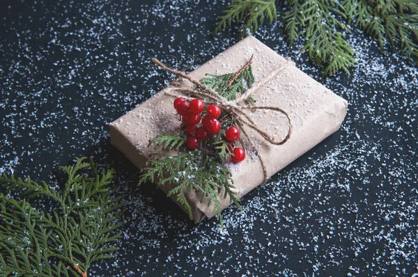 圣诞礼品盒 用牛皮纸制成 白雪覆盖在黑桌上 有冷杉枝条 母亲节 黑色星期五甩卖的平面设计 — 图库照片