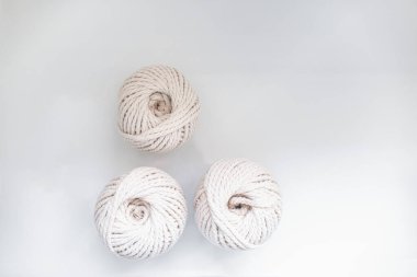 Açık arkaplanda örgü örmek için açık bej renkli bobinler.