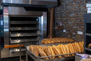 Ekmekler fırının tezgahında yan yana dizilmişti.