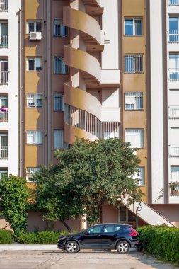 Araba yüksek binaların önüne park edilmiş, ön manzara.