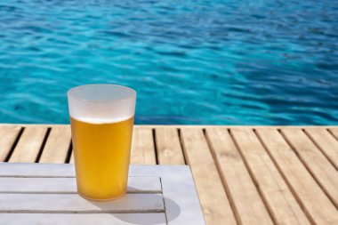 Bira kupası plajın yanında, ahşap zeminde duruyordu.