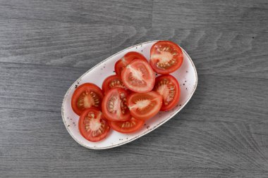 ahşap masanın üzerine dilimlenmiş domates