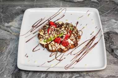 Çilekli Belçika waffle 'ı, yaban mersini ve şurup.