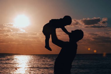 Gün batımında bir baba ve çocuğun silueti.. 