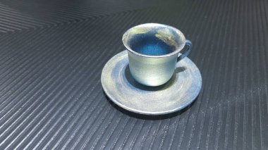 Simetrik çizgili metal arka planda kahve fincanı