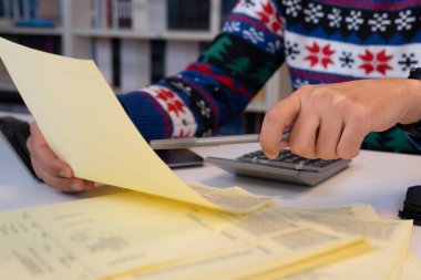 Ofiste çalışan genç işadamı Noel süveteri giyiyor.