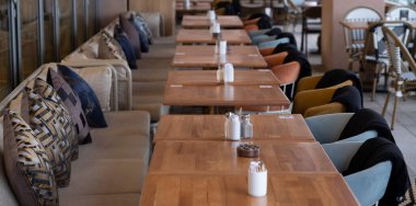 Lokantanın içi. Boş yemek masaları arka planda yan yana duruyor