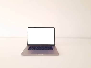 Öndeki beyaz masadaki dizüstü bilgisayar