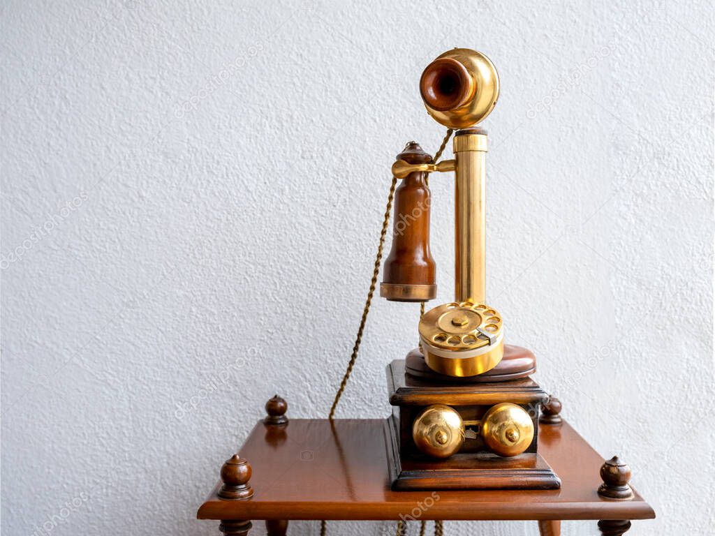 antique telephone in front of white wall