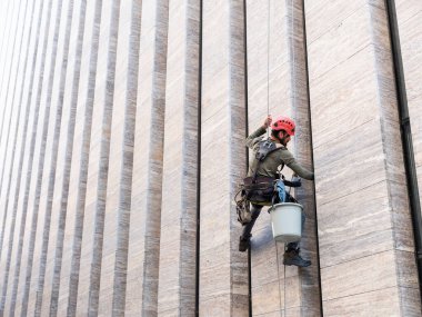 Pencere temizleyicisi ofis cephesinde çalışıyor.