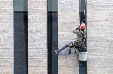 Pencere temizleyicisi ofis cephesinde çalışıyor.