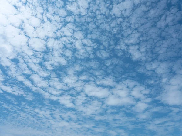 Deep blue skies with white clouds background with space for text, blue cloudy skies texture. front view