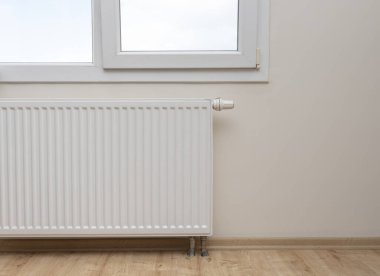Modern white radiator with thermostat