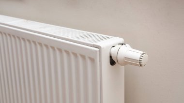 Modern white radiator with thermostat