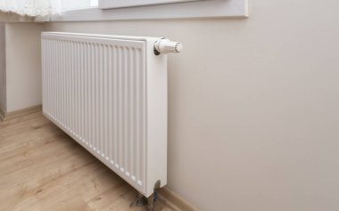 Modern white radiator with thermostat