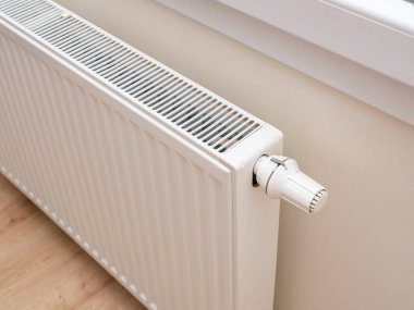 Modern white radiator with thermostat