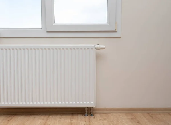 Modern white radiator with thermostat