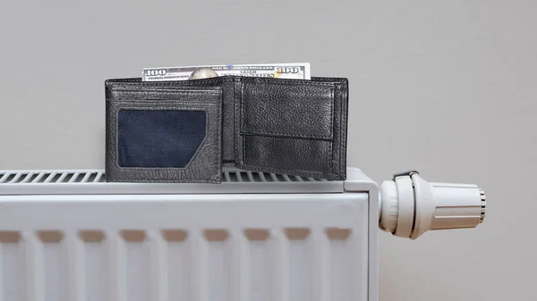 dollar banknotes on central heating radiator, the concept of expensive heating costs, front view
