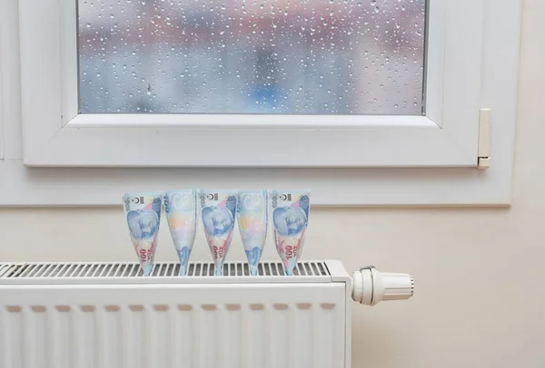 Turkish lira banknotes in a central heating radiator, the concept of expensive heating costs, close-up