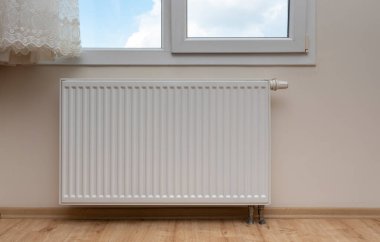 Modern white radiator with thermostat