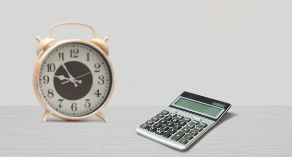 clock and calculator on the table. work and time concept. Front view