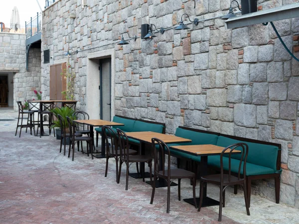 wooden table in front of coffee shop, front view