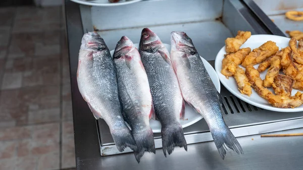 fresh fish in plate in fish restaurant, close up